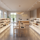 Modern retail store interior with white open shelving units displaying skincare and wellness products along both walls
